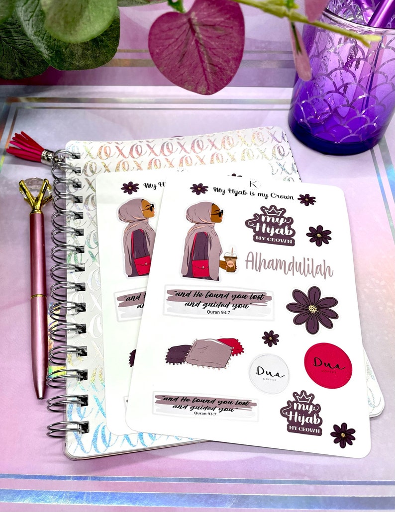 May include: A set of stickers featuring a woman wearing a hijab, a crown, and the text "My Hijab is my Crown". The stickers also include the text "Alhamdulilah", "Dua", and a Quran verse. The stickers are on a white background.