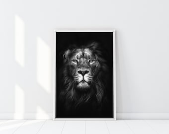 May include: Black and white photograph of a lion's face. The lion is looking directly at the camera with a serious expression. The background is black.