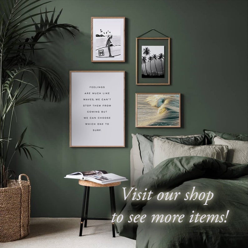 Puede incluir: Un interior de dormitorio con una pared verde y una cama con ropa de cama verde y beige. Hay tres impresiones enmarcadas en la pared, una con una cita sobre los sentimientos, una con un surfista y otra con palmeras. Una peque&ntilde;a mesa auxiliar con una tapa de corcho se encuentra junto a la cama. El texto "&iexcl;Visita nuestra tienda para ver m&aacute;s art&iacute;culos!" est&aacute; escrito en blanco sobre un fondo verde.