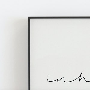 May include: A black framed print with the word "in" written in cursive.