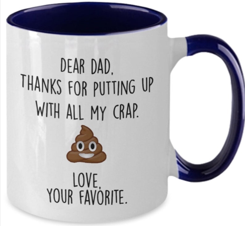 May include: White ceramic mug with a navy blue interior and handle. The mug features the text "DEAR DAD. THANKS FOR PUTTING UP WITH ALL MY CRAP. LOVE, YOUR FAVORITE." along with a cartoon poop emoji.