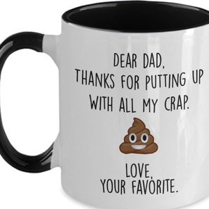 May include: White ceramic mug with a black handle and interior. The mug features the text "DEAR DAD, THANKS FOR PUTTING UP WITH ALL MY CRAP. LOVE, YOUR FAVORITE." and a cartoon poop emoji.