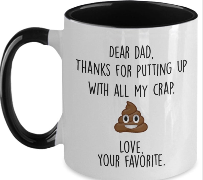 May include: White ceramic mug with a black handle and interior. The mug features the text "DEAR DAD, THANKS FOR PUTTING UP WITH ALL MY CRAP. LOVE, YOUR FAVORITE." and a cartoon poop emoji.