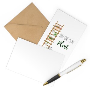 May include: A white card with a brown envelope and a black pen. The card features a watercolor illustration of a wooden ladder with potted plants and the text "Just one more plant".