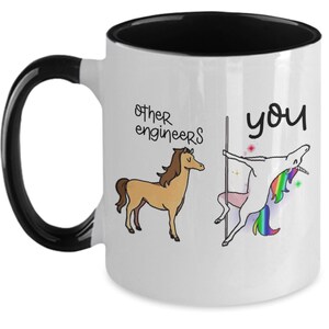 May include: White ceramic mug with a black interior and handle. The mug features a cartoon illustration comparing "other engineers" to a horse and "you" to a unicorn doing a pole dance. The text is in black cursive.