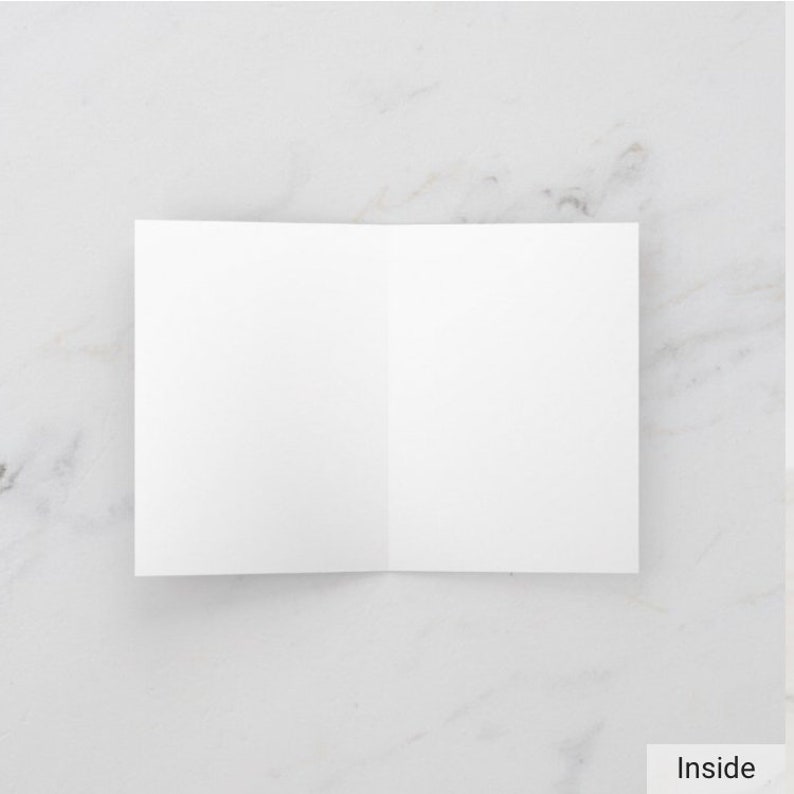 May include: Blank white card folded in half, ready for a handwritten message.