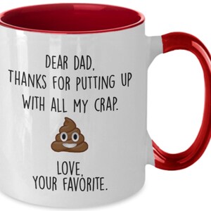 May include: White ceramic mug with a red interior and handle. The mug features the text "DEAR DAD, THANKS FOR PUTTING UP WITH ALL MY CRAP. LOVE, YOUR FAVORITE." along with a cartoon poop emoji.