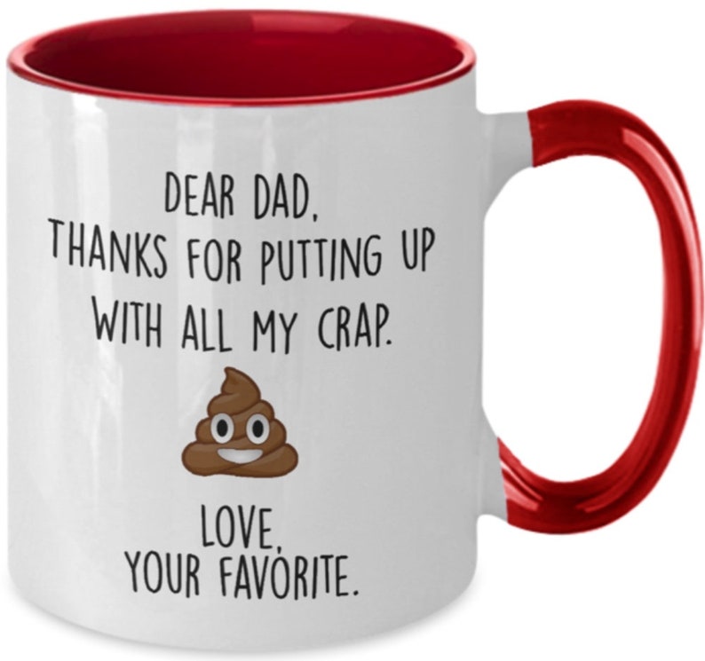 May include: White ceramic mug with a red interior and handle. The mug features the text "DEAR DAD, THANKS FOR PUTTING UP WITH ALL MY CRAP. LOVE, YOUR FAVORITE." along with a cartoon poop emoji.