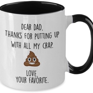 May include: White ceramic mug with a black interior and handle. The mug features the text "DEAR DAD, THANKS FOR PUTTING UP WITH ALL MY CRAP. LOVE, YOUR FAVORITE." and a cartoon poop emoji.