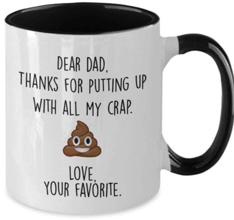 May include: White ceramic mug with a black interior and handle. The mug features the text "DEAR DAD, THANKS FOR PUTTING UP WITH ALL MY CRAP. LOVE, YOUR FAVORITE." and a cartoon poop emoji.