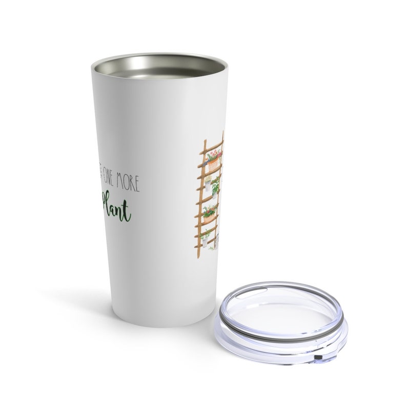 Puede incluir: Vaso de viaje blanco con borde plateado y tapa transparente. El vaso presenta una ilustraci&oacute;n de acuarela de una escalera de plantas de madera con plantas en macetas. El texto en el vaso dice "Just one more plant."