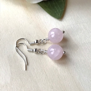 May include: A pair of silver dangle earrings with pale pink round gemstone beads.