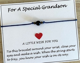 May include: A card with the text "For A Special Grandson" and a blue string bracelet with a black bead. The card also has the text "A Little Wish For You" and instructions on how to make a wish with the bracelet.