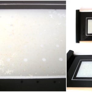 May include: A black framed picture with a white mat and a white background. The picture is slightly dirty.
