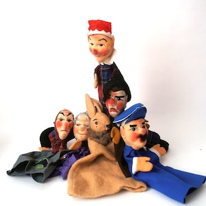 May include: A set of six finger puppets, including a rabbit, a woman with a red scarf, a man with a red hat, a man with a blue hat, a woman with a green scarf, and a man with a black hat.