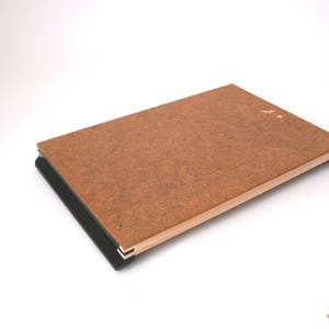 May include: A brown wooden board with black edging, the board is slightly warped and has a light brown wood frame.