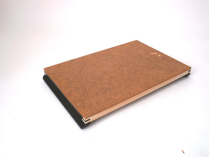 May include: A brown wooden board with black edging, the board is slightly warped and has a light brown wood frame.