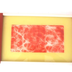 May include: A red and white tray with a white frame and a red border. The tray has a yellow background and a red and white abstract design in the center.