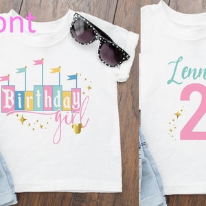 Peut inclure: Deux t-shirts blancs avec un motif rose et or. Le premier t-shirt dit "Birthday girl" avec un graphique de château et des étoiles dorées. Le deuxième t-shirt dit "Lenna 2" avec un numéro 2 rose et des étoiles dorées.