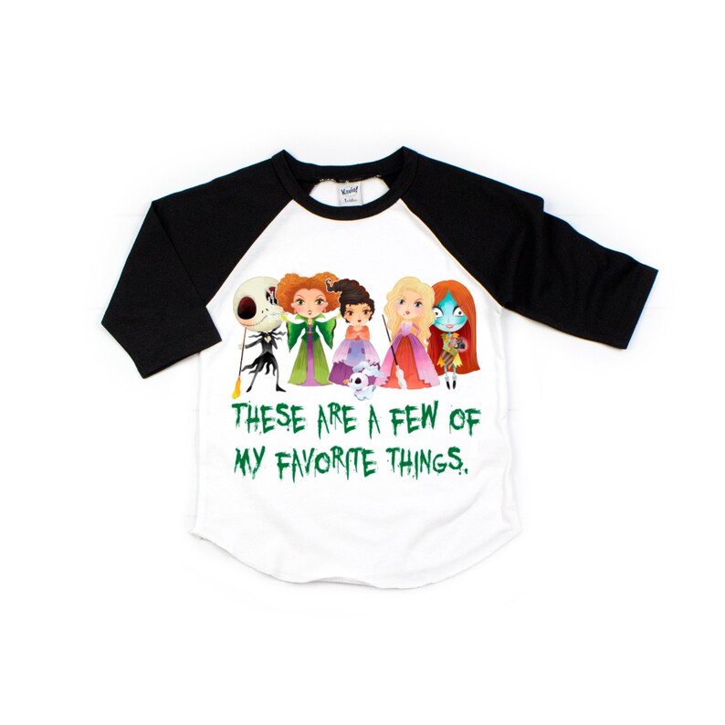 Puede incluir: Una camiseta de b&eacute;isbol blanca y negra con un gr&aacute;fico verde de personajes de pel&iacute;culas populares de Halloween. El texto "These are a few of my favorite things." est&aacute; impreso en verde debajo del gr&aacute;fico.