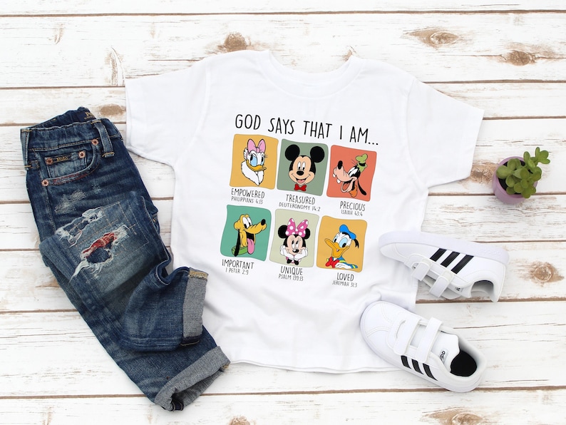 May include: White t-shirt with a graphic of Disney characters and the text "GOD SAYS THAT I AM..." with bible verses underneath each character.