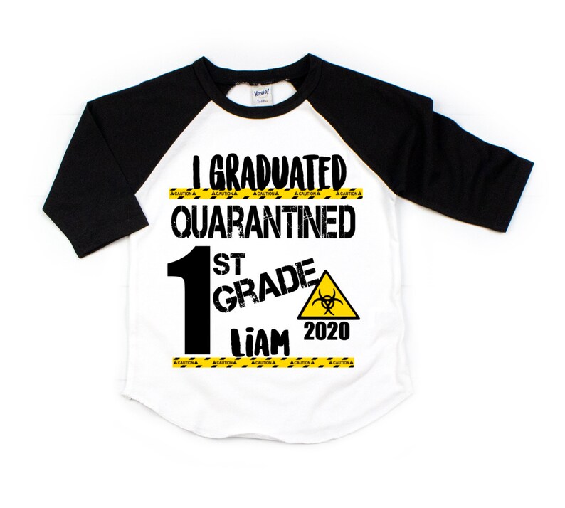 May include: A white and black baseball style t-shirt with the text "I Graduated Quarantined 1st Grade Liam 2020" and a yellow caution tape design.