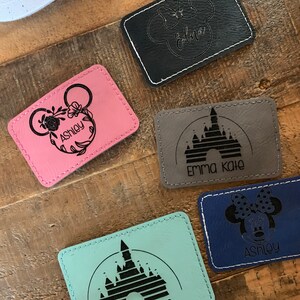 Pu&ograve; includere: Cinque toppe in pelle personalizzate con diversi design di personaggi Disney e nomi. Le toppe sono di vari colori, tra cui rosa, nero, grigio, blu e turchese. I nomi sulle toppe includono Ashley, Edna, Emma Kate e Ashley.
