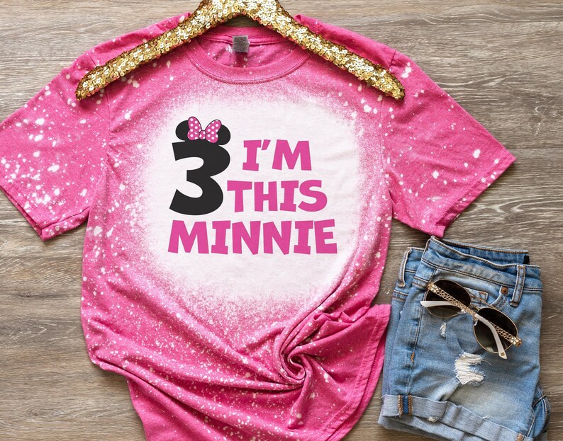 May include: Pink bleached t-shirt with a black number 3 and the text "I'm this Minnie" in pink. The number 3 has a pink bow on top.