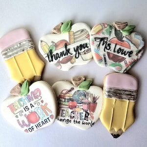 May include: Assortment of decorated sugar cookies in the shape of pencils and apples. The apple cookies have messages like "thank you", "Ms. Lowe", and "Teaching is a work of heart". The cookies are decorated with edible ink.