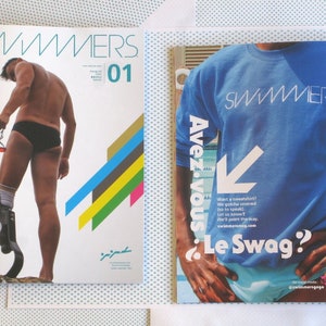May include: A magazine cover with the title "Swimmers" and the number "01" printed on it. The cover features a man wearing a blue swimsuit and a prosthetic leg. The magazine cover also features a colorful graphic design with stripes.