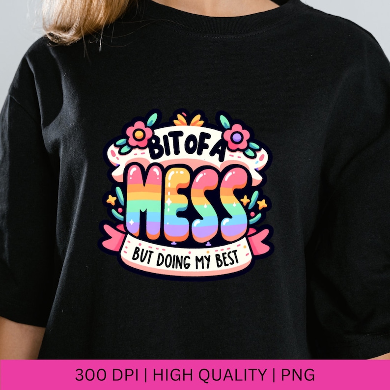 May include: A black t-shirt with a rainbow-colored graphic that says "Bit of a Mess But Doing My Best".