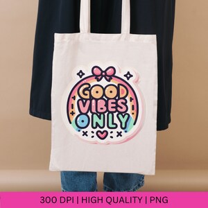 May include: White tote bag with a rainbow and the text "Good Vibes Only" in a pink, blue, and yellow color scheme. The text is surrounded by stars and a pink bow.