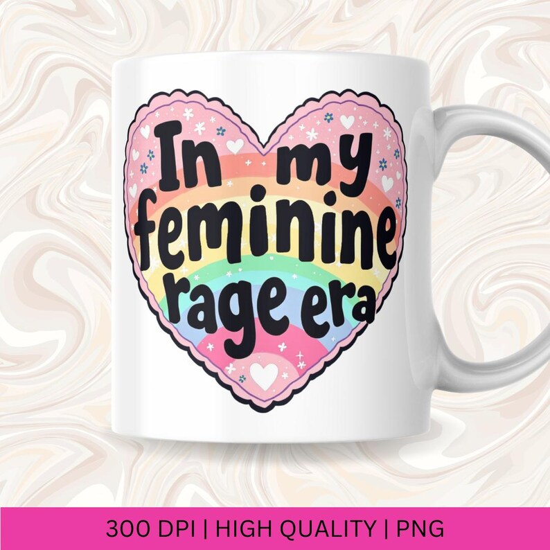 May include: White ceramic mug with a rainbow heart design. The heart has the text "In my feminine rage era" in black lettering.