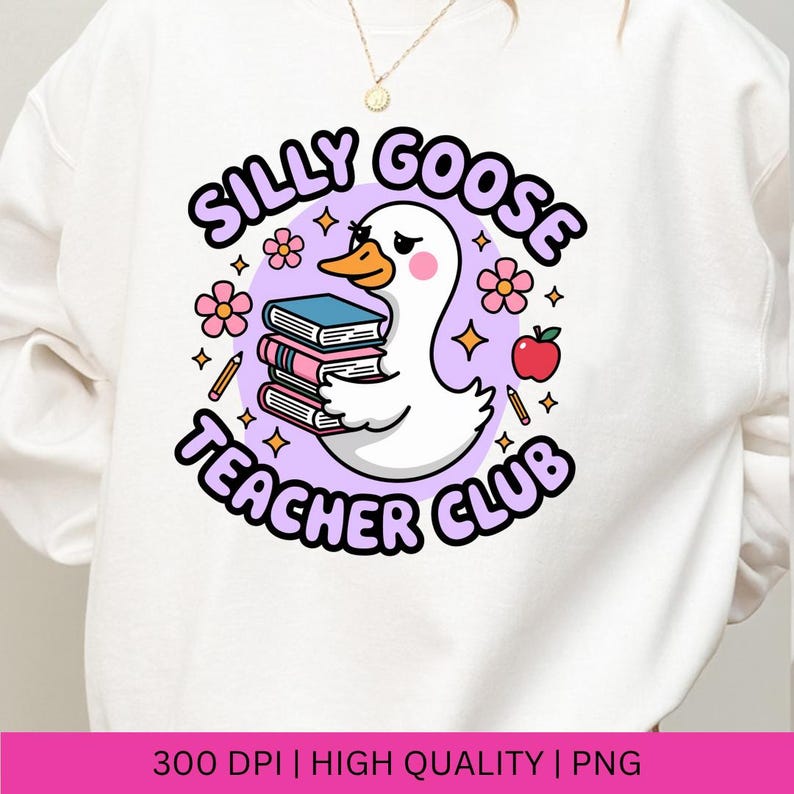 Op de afbeelding: Witte sweatshirt met een cartoon gans die boeken vasthoudt, met de tekst "Silly Goose Teacher Club" in een paarse cirkel. Het ontwerp bevat bloemen, potloden, een appel en sterren. Hoogwaardige PNG-afbeelding.