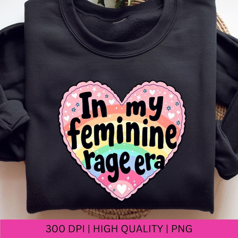 May include: A black sweatshirt with a rainbow heart design that says "In my feminine rage era".
