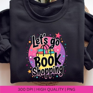 K&ouml;nnte beinhalten: Schwarzes Sweatshirt mit einem bunten Grafikdesign, auf dem "Let's go book shopping" steht. Die Grafik zeigt eine Einkaufstasche gef&uuml;llt mit B&uuml;chern und einen Stern.