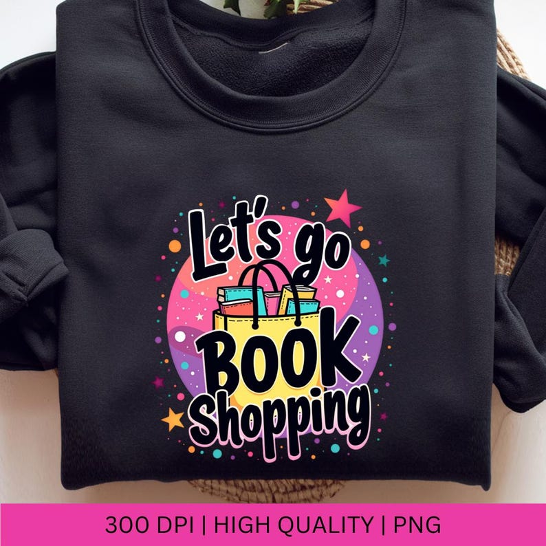 K&ouml;nnte beinhalten: Schwarzes Sweatshirt mit einem bunten Grafikdesign, auf dem "Let's go book shopping" steht. Die Grafik zeigt eine Einkaufstasche gef&uuml;llt mit B&uuml;chern und einen Stern.