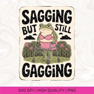 Puede incluir: Una rana verde con un sujetador y una falda rosa camina con un andador. El texto "Sagging but still Gagging" está escrito en letras negras sobre un fondo crema.