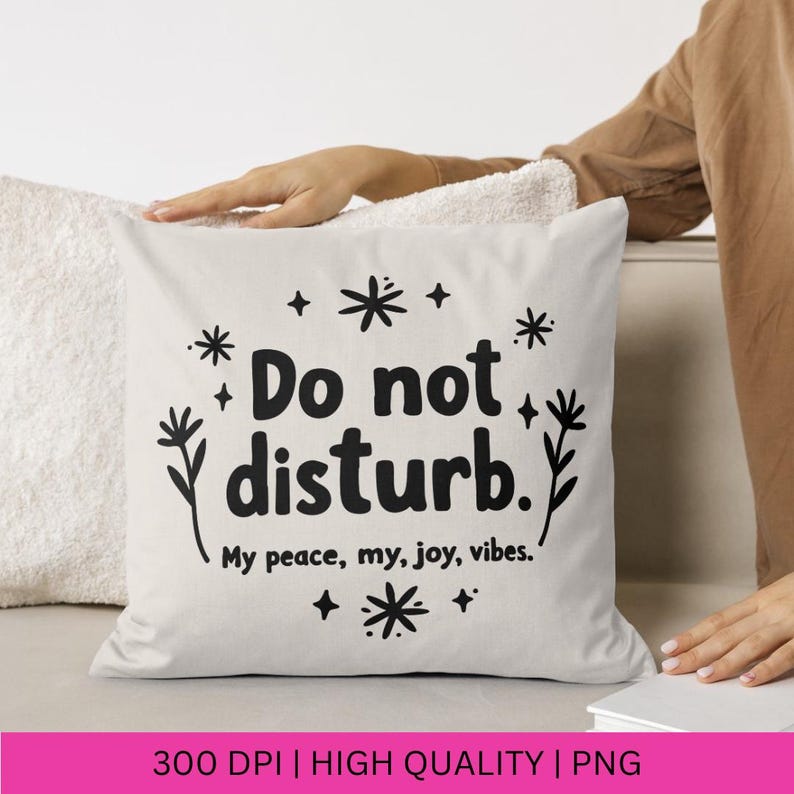 Puede incluir: Almohada blanca con texto negro que dice "No molestar. Mi paz, mi alegr&iacute;a, mis vibraciones." con peque&ntilde;as ilustraciones de flores negras a cada lado del texto.