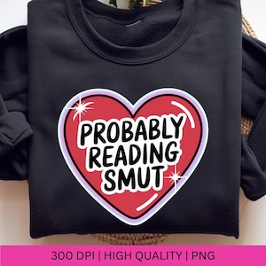 Pu&ograve; includere: Felpa nera con grafica a cuore rosso con la scritta bianca "PROBABLY READING SMUT". Il cuore ha un contorno bianco e azzurro con accenti a stella. In basso all'immagine c'&egrave; la scritta "300 DPI | HIGH QUALITY | PNG".