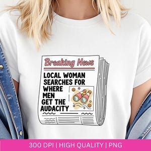 May include: White t-shirt featuring a newspaper graphic with the headline "Breaking News." The text reads "Local Woman Searches For Where Men Get The Audacity." The graphic includes binoculars and smiley faces.