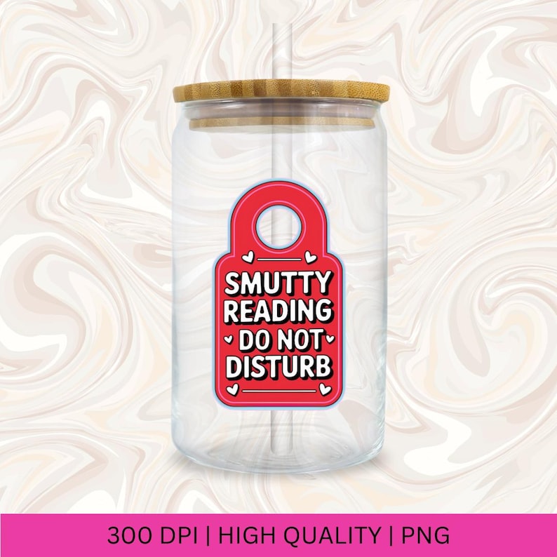 Pu&ograve; includere: Un bicchiere di vetro trasparente con coperchio in bamb&ugrave; e una grafica rossa a forma di etichetta. La grafica recita "Smutty Reading Do Not Disturb" in testo bianco, con accenti a cuore. Una cannuccia &egrave; visibile all'interno del bicchiere.