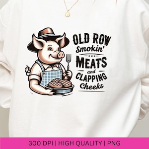 May include: A white sweatshirt with a cartoon pig wearing a hat and holding a plate of grilled meat. The text "Old Row Smokin' Meats and Clapping Cheeks" is printed on the sweatshirt.