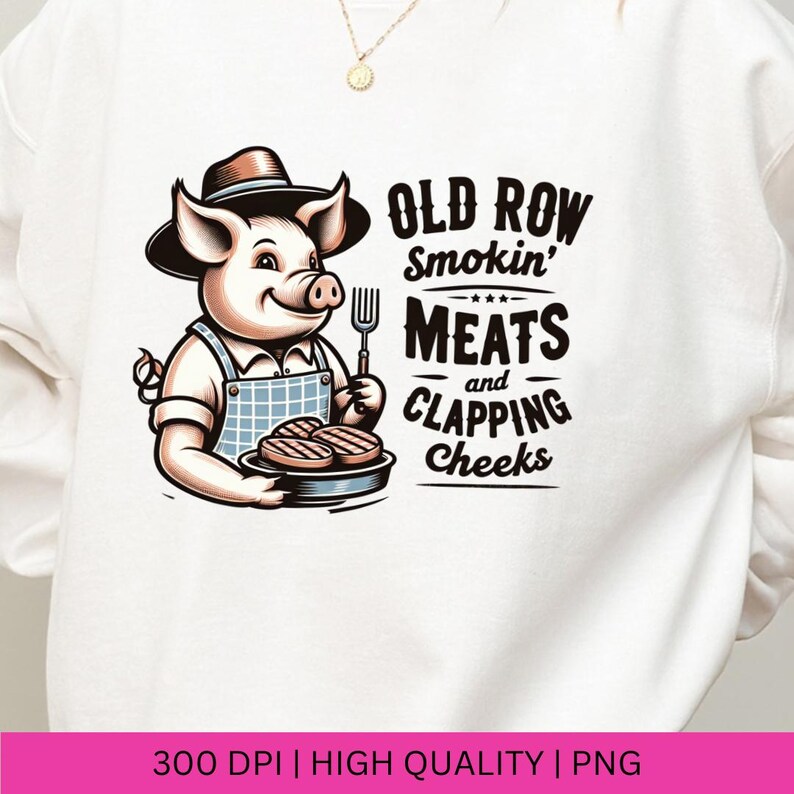 May include: A white sweatshirt with a cartoon pig wearing a hat and holding a plate of grilled meat. The text "Old Row Smokin' Meats and Clapping Cheeks" is printed on the sweatshirt.