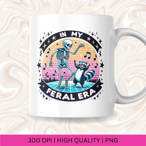 May include: White ceramic mug featuring a colourful graphic of a skeleton and a raccoon dancing on a retro-style dance floor. The text "In My Feral Era" is printed in a colourful font around the graphic.
