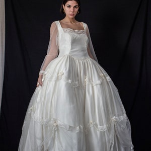 197 - Robe de mariée de princesse en tulle de soie et satin : robe ivoire à volants, manches longues et boutons. Style Scarlett O'Hara, effet nuage.