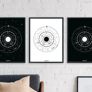 May include: Three black framed prints with white celestial designs. Each print features a circle with concentric rings and a star in the center. The designs are similar but have subtle variations.