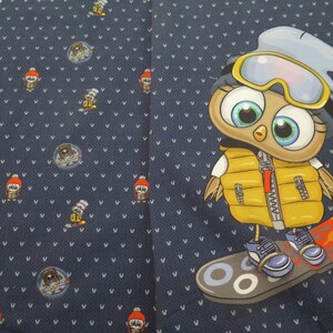 Peut inclure: Un tissu bleu avec un motif répété de hiboux portant des bonnets d'hiver et tenant des bâtons de ski. Un hibou plus grand portant un gilet jaune et un bonnet bleu fait du snowboard sur un snowboard rouge et jaune.