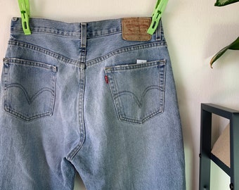 May include: A pair of light blue denim jeans with a brown leather patch that reads "Levi Strauss & Co."