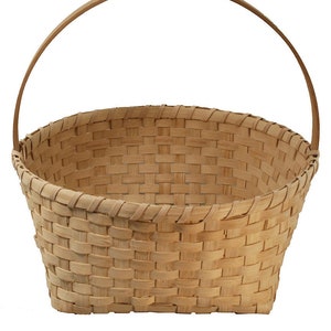 May include: A natural woven basket with a wooden handle. The basket is oval shaped and has a light brown color.